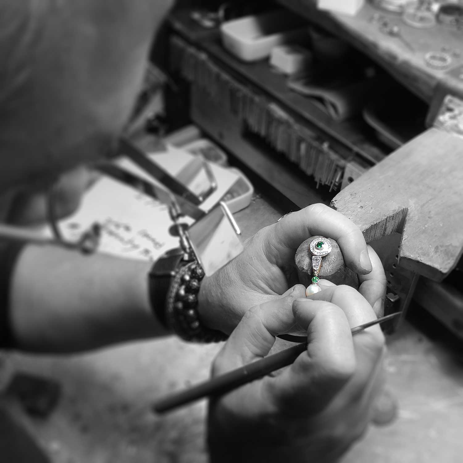 Goldsmith Phil Dismuke inspecting a custom handcrafted earring at Jewelsmith's on-site workshop in Durham NC