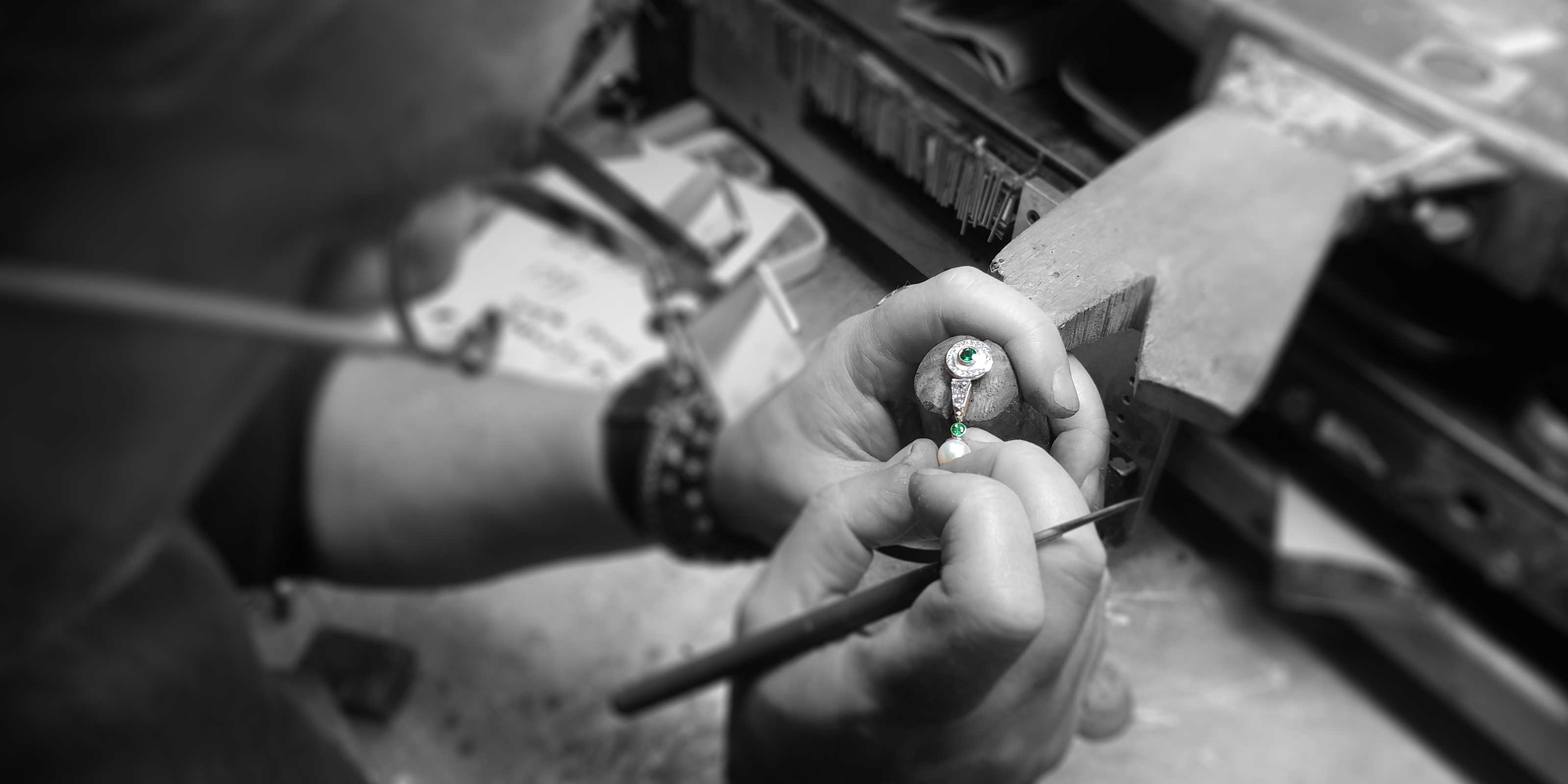 Goldsmith Phil inspecting earring that he just created