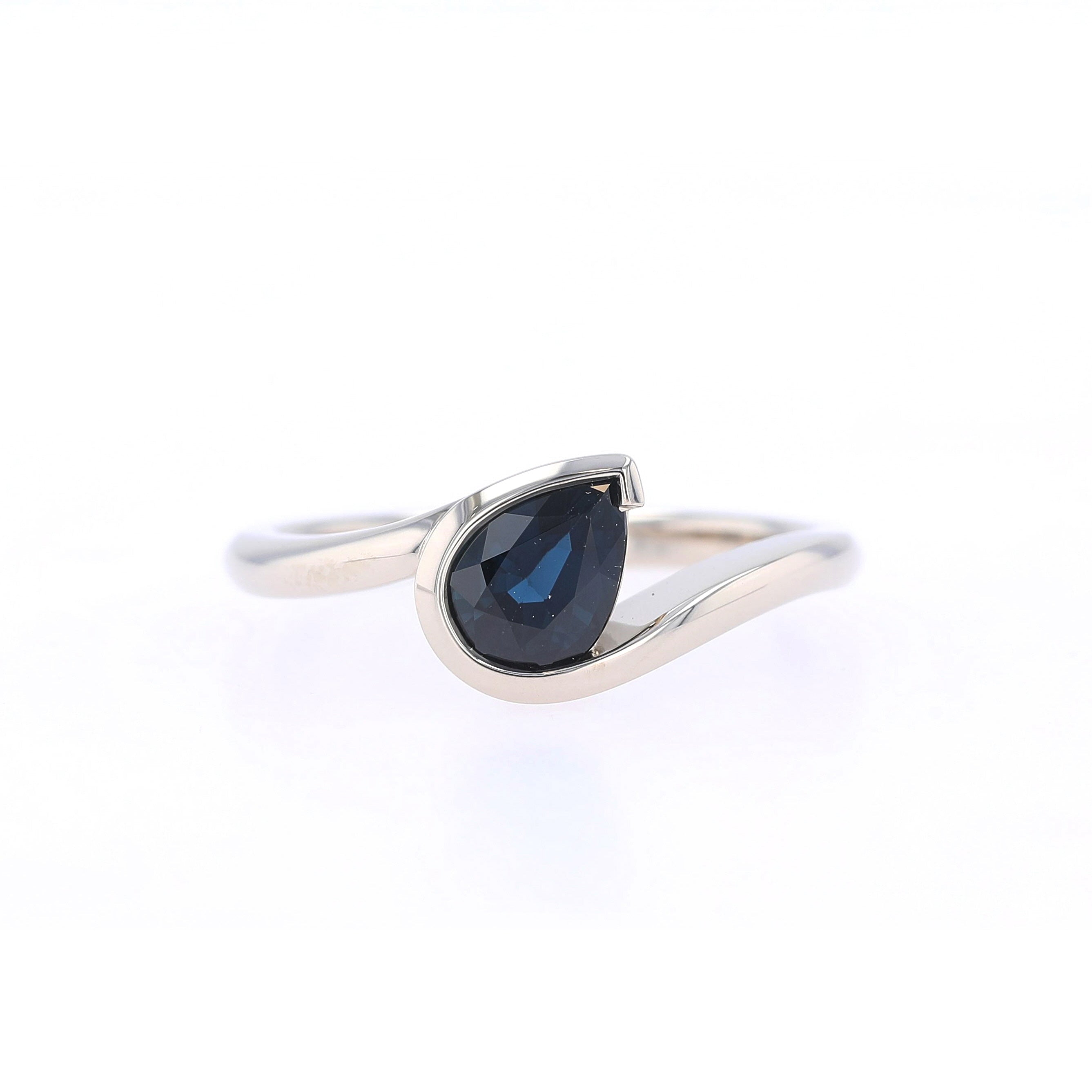 pear shaped blue sapphire set in asymmetrical bypass engagement ring