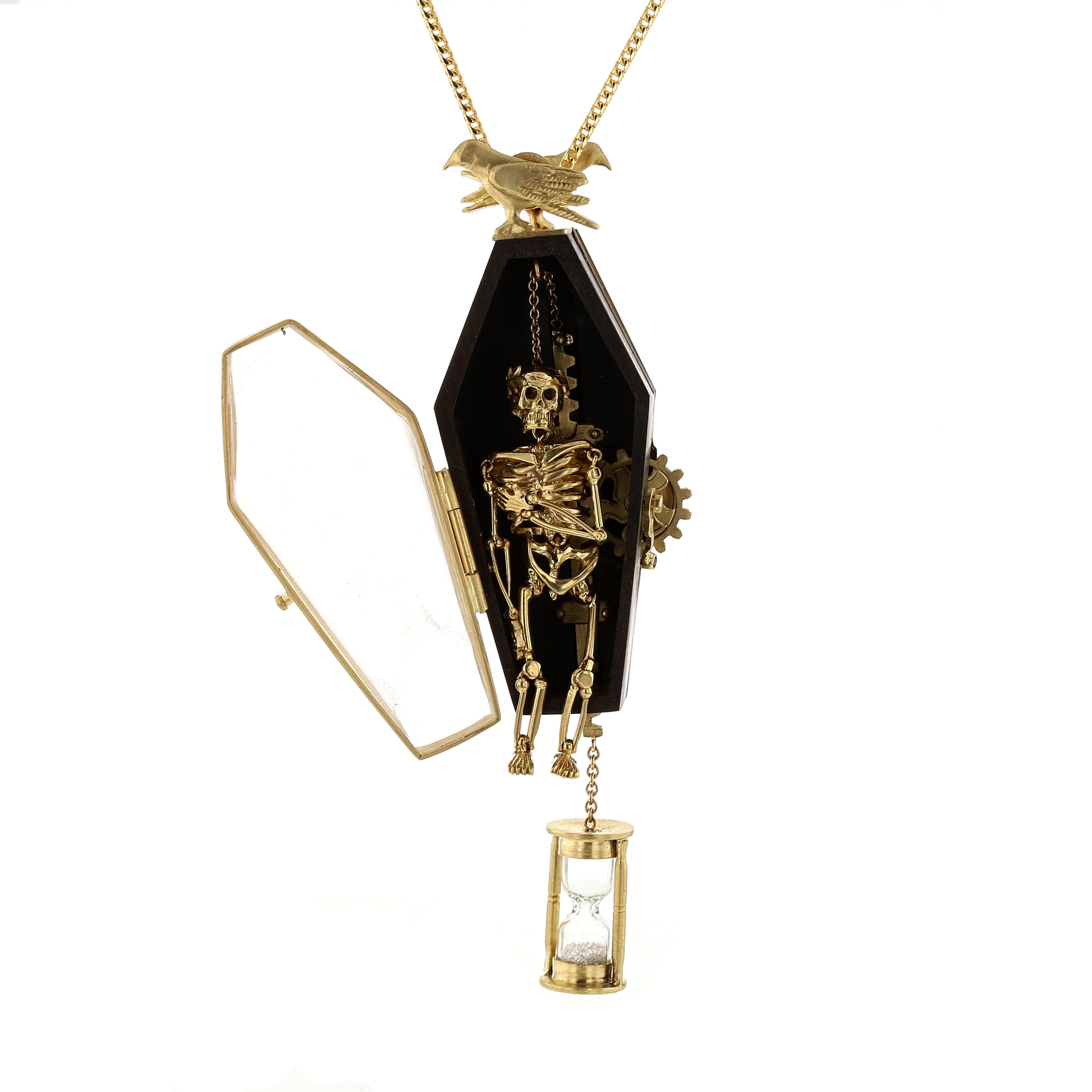 momento mori pendant with gear driven moving skeleton in coffin with quartz door that opens and diamond filled hour glass