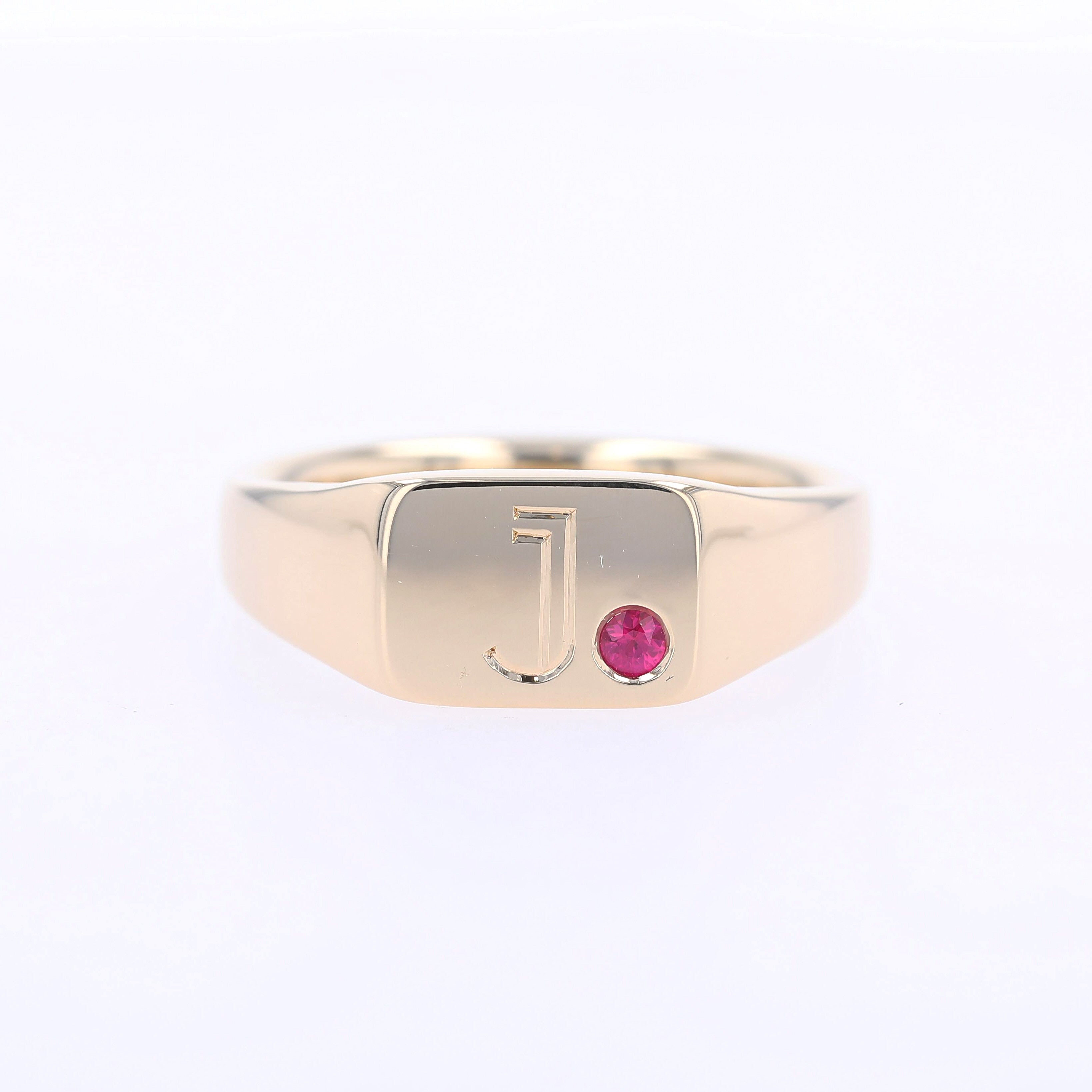 gold signet ring with hand engraved J and flush set ruby