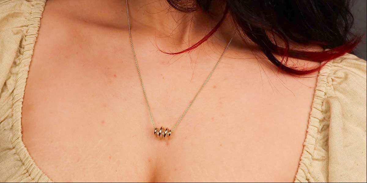 model wearing small spiral pendant representing petite jewelry