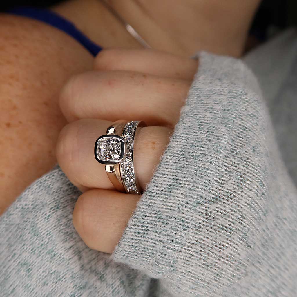 model wearing floating bezel engagement ring and diamond band