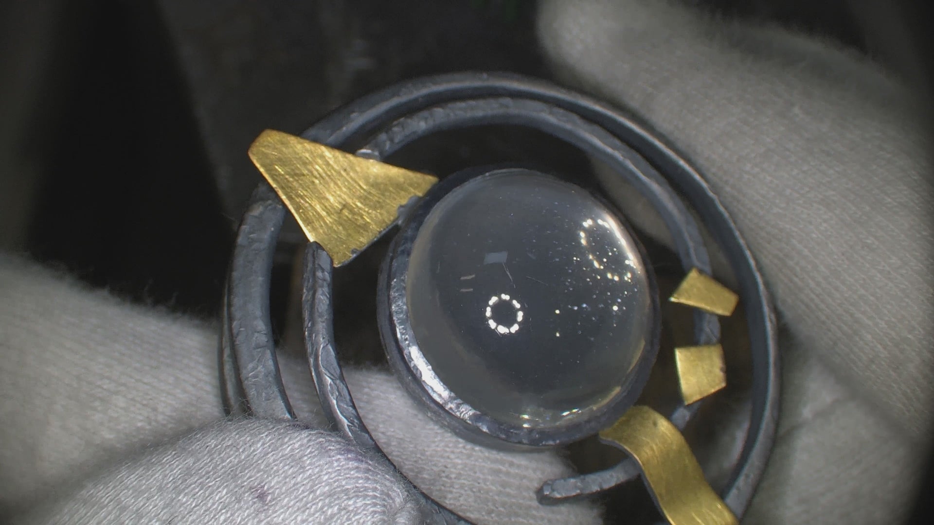 pendant with moonstone being turned in the light to show sparkles inside gem